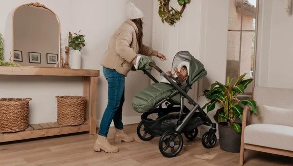 Image of Mum going outdoors with child in the Vista V3, cosy in the new winter footmuff.