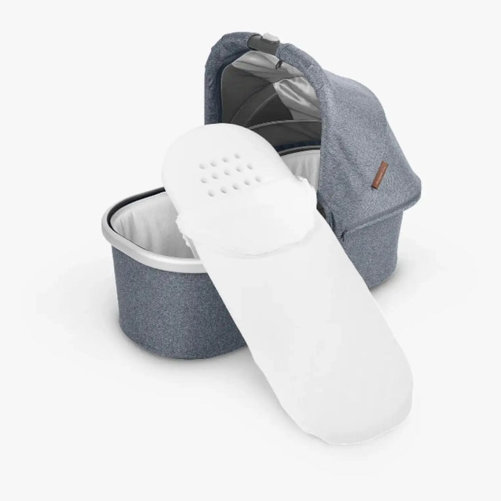 UPPAbaby carrycot/bassinet mattress cover in white shown with carrycot, breathable vent holes visible