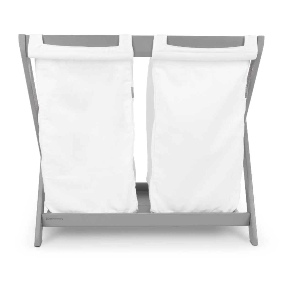 UPPAbaby Carrycot Stand Hamper Insert on grey stand, featuring two removable white fabric laundry bags that convert the UPPAbaby Carrycot Stand into a functional nursery hamper.