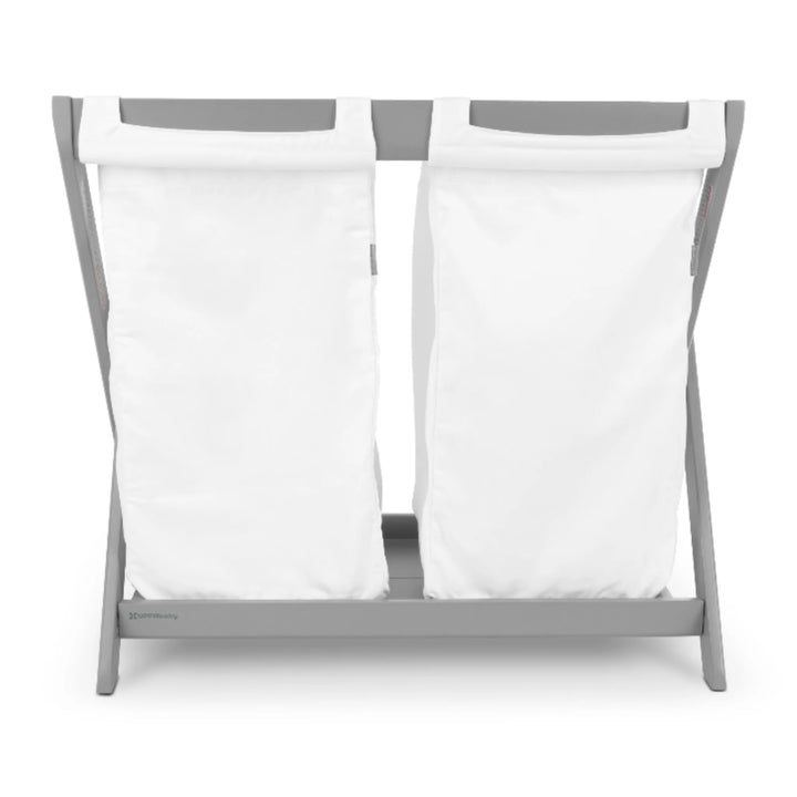 UPPAbaby Carrycot Stand Hamper Insert on grey stand, featuring two removable white fabric laundry bags that convert the UPPAbaby Carrycot Stand into a functional nursery hamper.