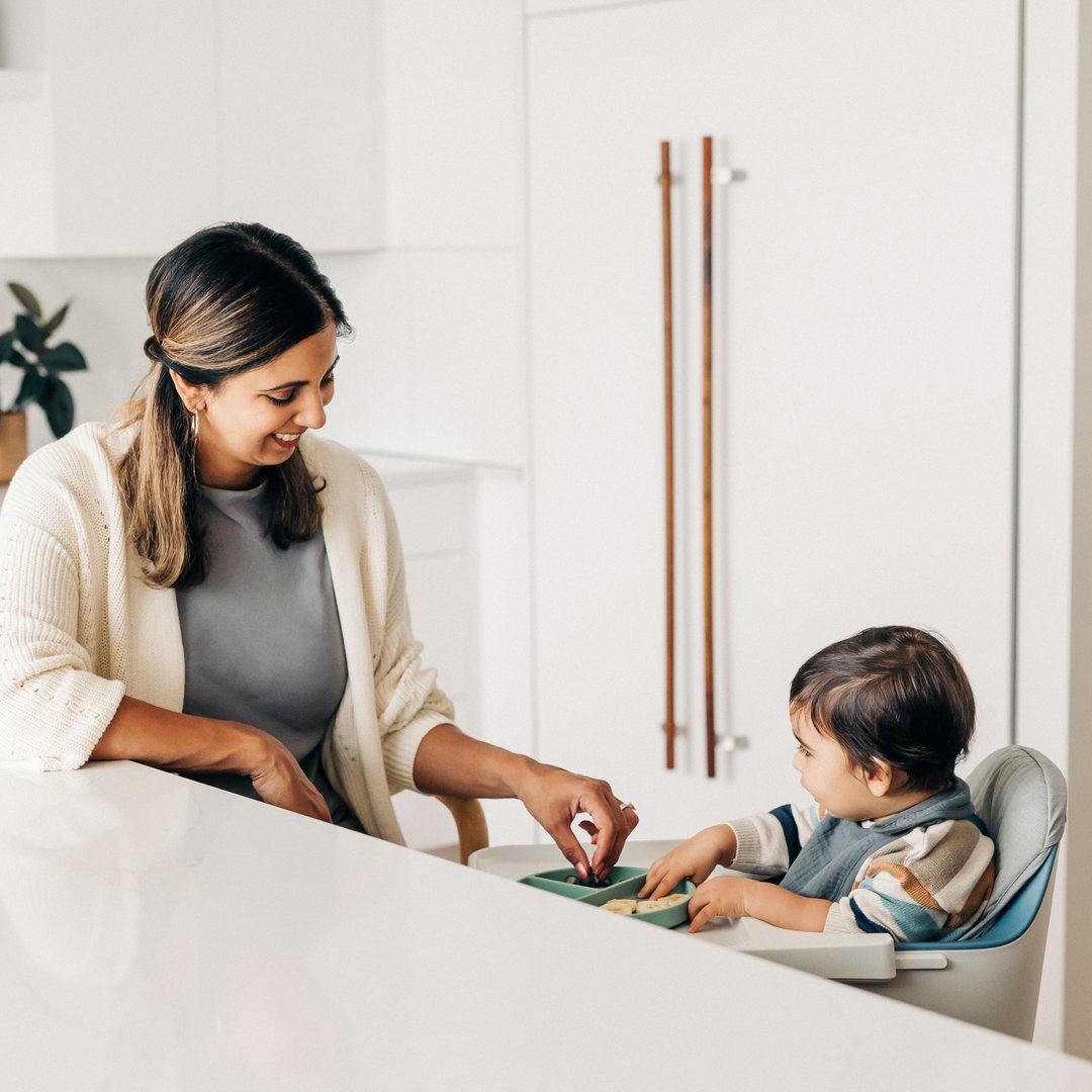 This image shows a Mom feeding her child a snack in the Ciro high chair with the high chair cushion being used