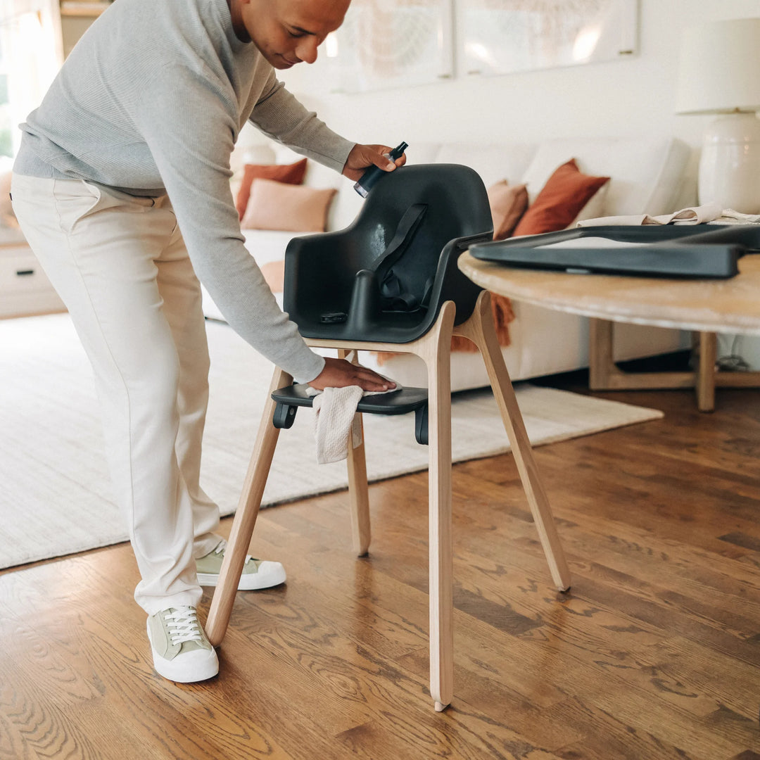 Dad wiping down the Ciro high chair with spray and cloth.