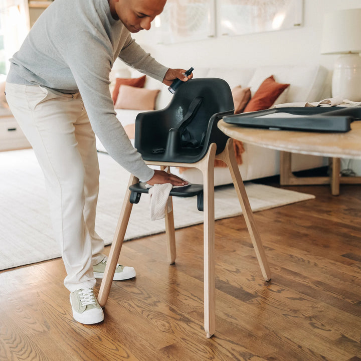 Dad wiping down the Ciro high chair with spray and cloth.
