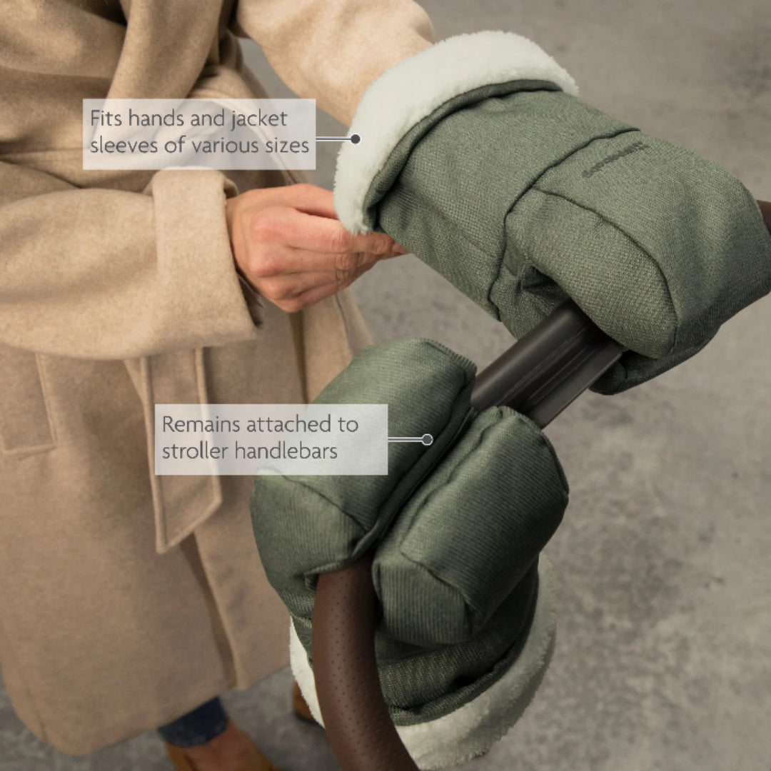 UPPAbaby Cozy Handmuffs Dillon stroller hand warmers attached to pushchair handlebars, showing adjustable fit over hands and jacket sleeves with secure attachment for cold weather прогулки.