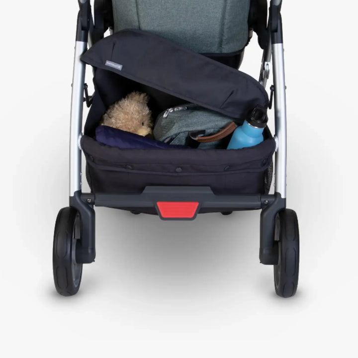 UPPAbaby Cruz 2015–2019 basket cover installed on stroller under-seat storage basket, holding accessories