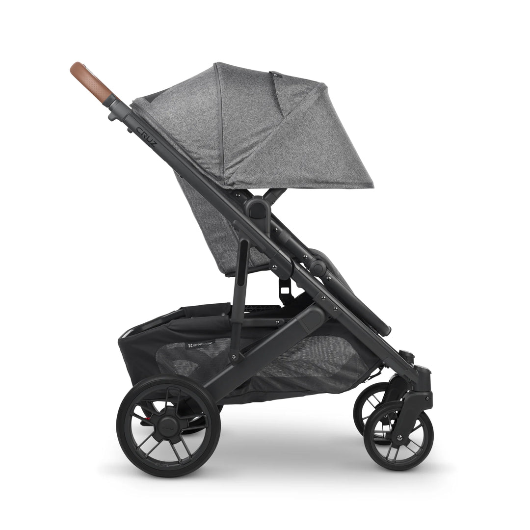 UPPAbaby Cruz V2 Greyson stroller side view – grey lightweight pushchair with extended sun canopy, leather handlebar, and spacious storage basket for modern family travel.