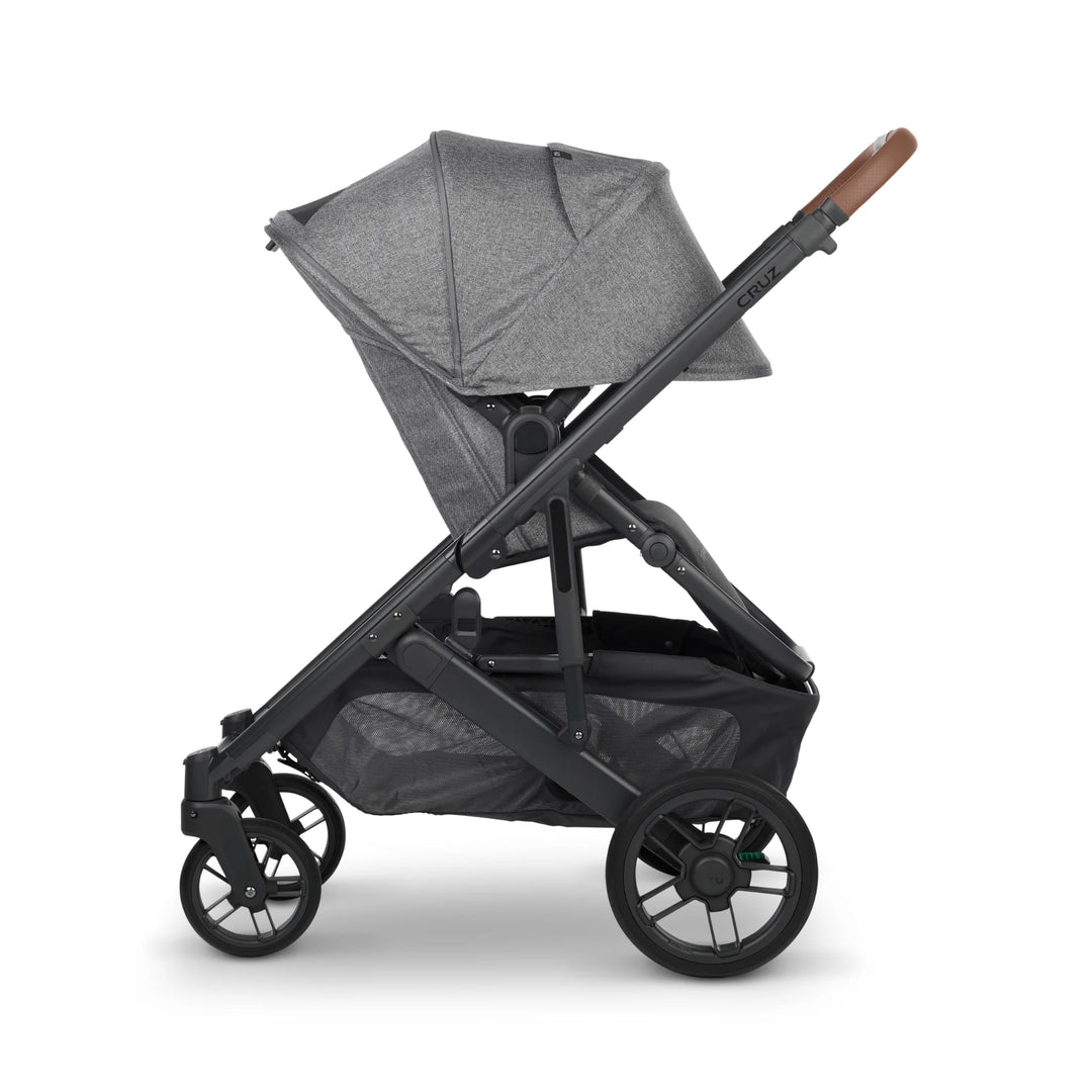 “UPPAbaby Cruz V2 Greyson stroller in side profile – grey premium pushchair with fully extended canopy, leather handlebar, and large storage basket designed for modern parents on the go.