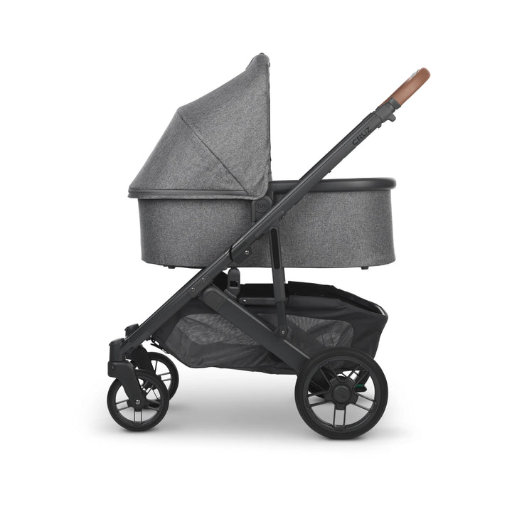 UPPAbaby Cruz V2 Greyson stroller with bassinet side view – stylish grey travel system featuring leather handlebar, ventilated canopy, and spacious storage basket for newborn comfort and urban living.