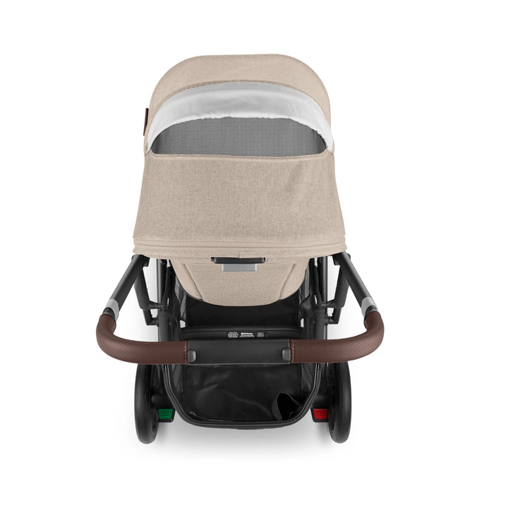 Rear view of UPPAbaby Cruz V2 Liam stroller – beige pushchair with leather handlebar, ventilated canopy window, and spacious under-seat basket for modern family travel.