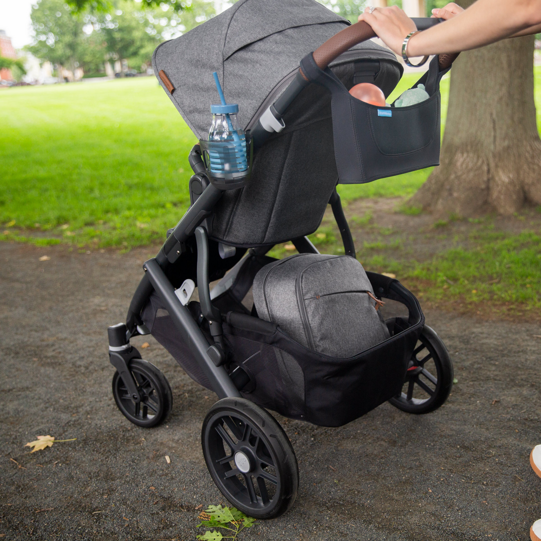 This image shows the cup holder in use on a Greyson Vista V2 stroller holding a water bottle.