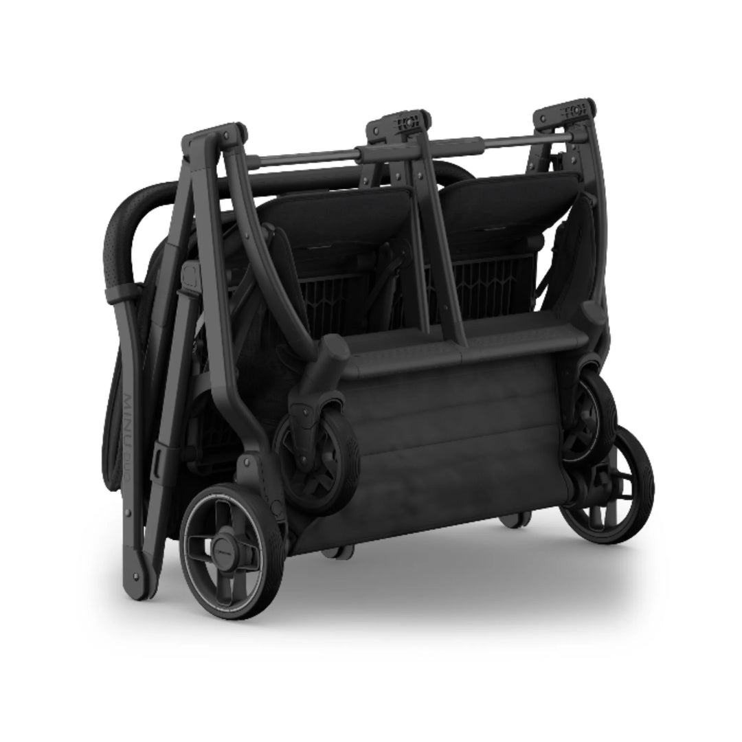 UPPAbaby Minu Duo double stroller folded in Jake black, compact two-seat twin/sibling pushchair on white background