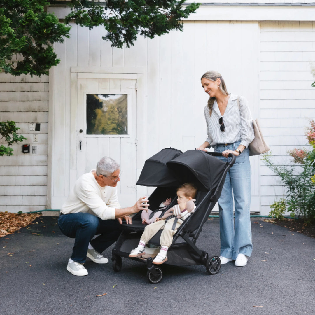 Grandparents with child in UPPAbaby Minu Duo double stroller in Jake black, easy-to-push twin/sibling pushchair outdoors
