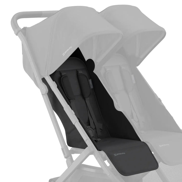 UPPAbaby Minu Duo stroller with black (Jake) replacement seat fabric installed on the left seat, with the opposite seat faded on a white background.