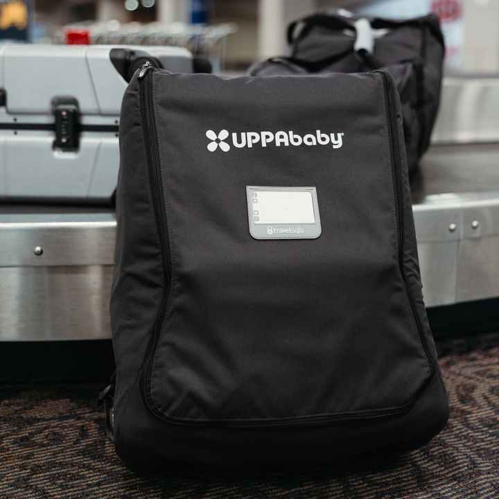 This is an image of the Minu travel bag with the stroller inside, propped up against the baggage claim belt