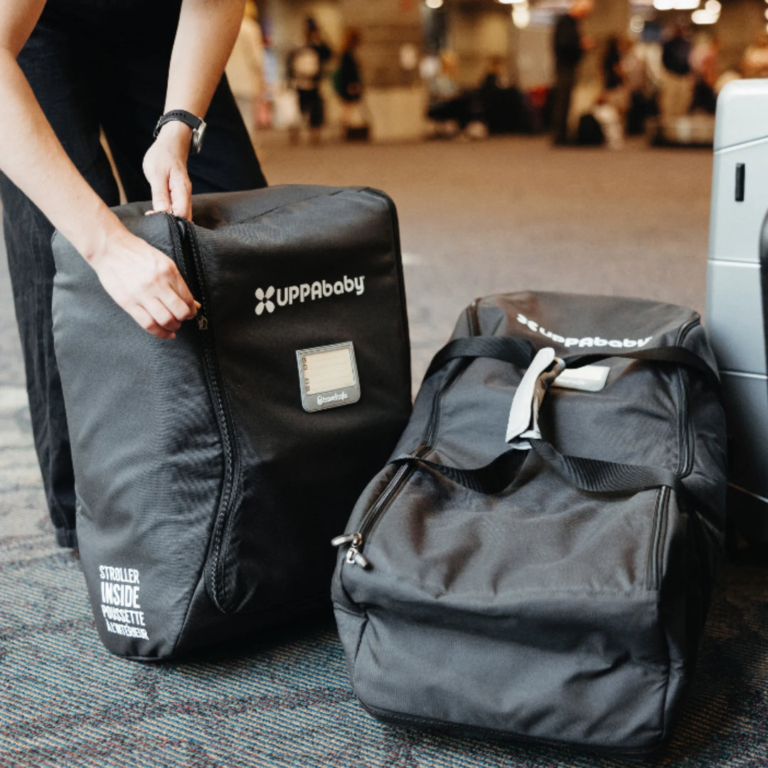 UPPAbaby Minu stroller travel bag at the airport beside luggage, ready for check-in.