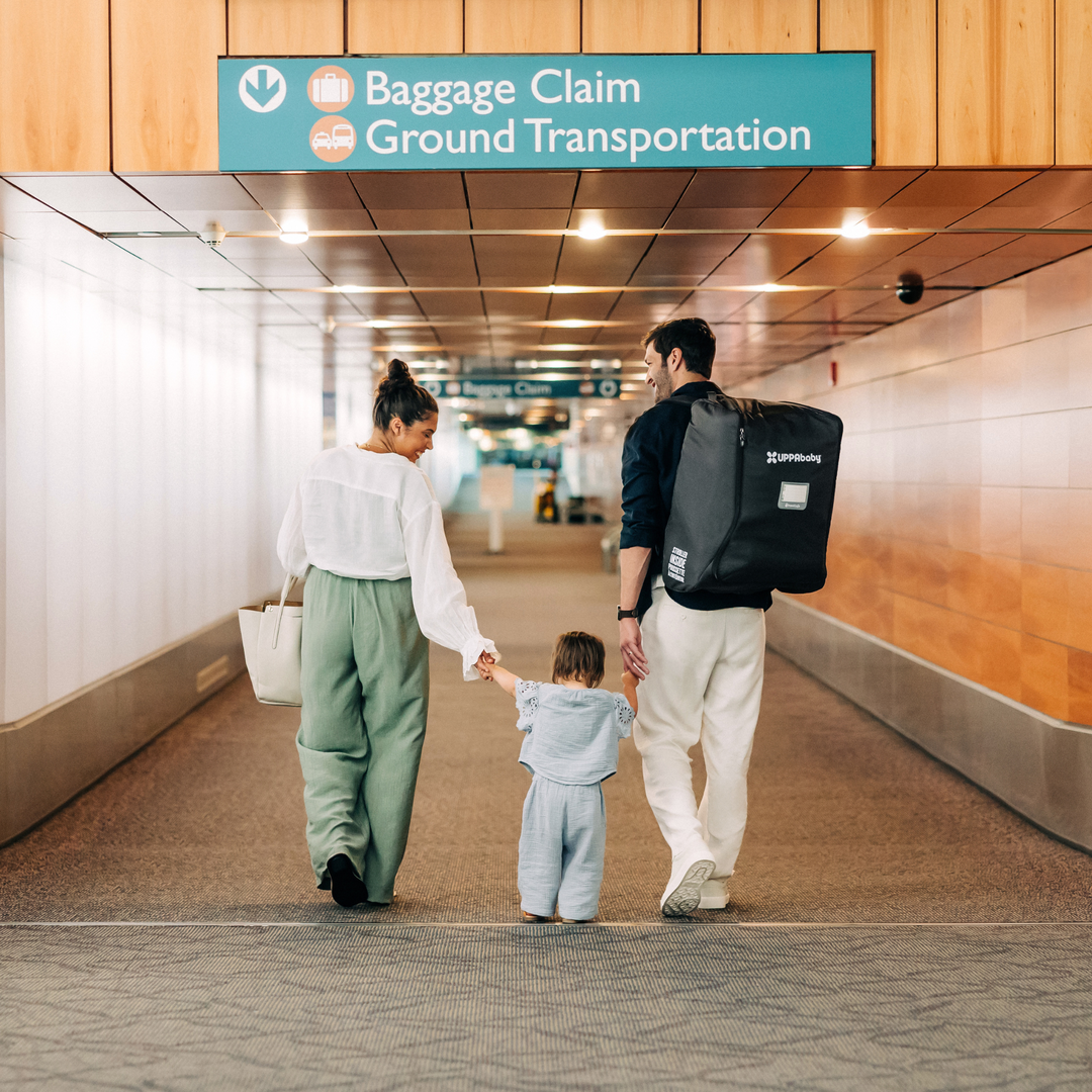 This image showcases a family walking towards the baggage claim in the airport and the dad has the Minu in their travel bag on his back