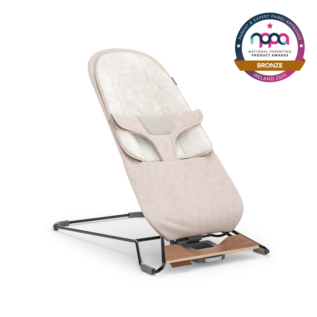 UPPAbaby baby bouncer in beige colour with bronze NPPA logo on white background.