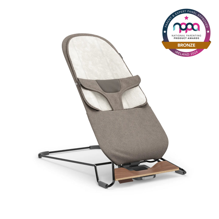 UPPAbaby baby bouncer in taupe colour with bronze NPPA logo on white background.