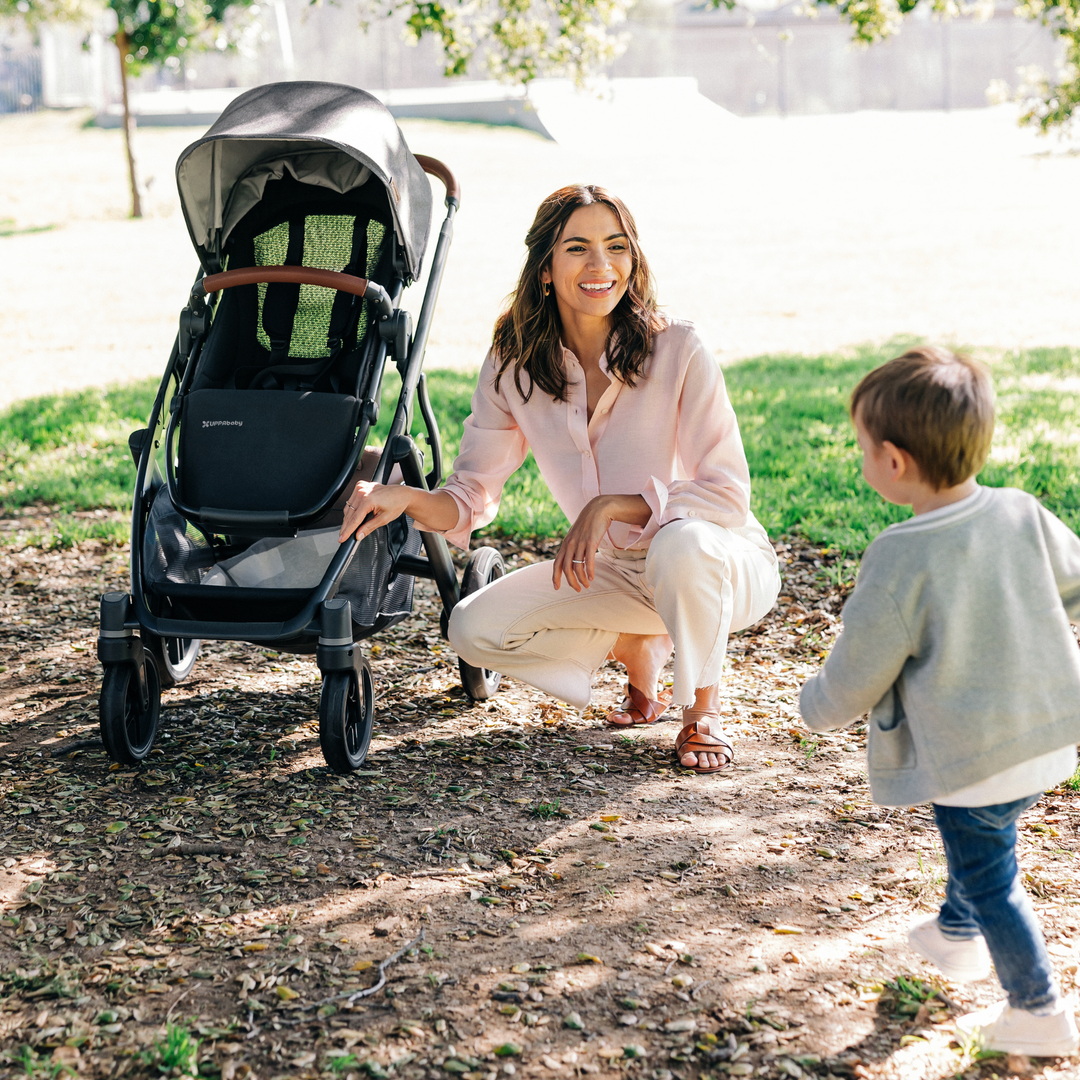 This image shows a Mum and a child outdoors on a sunny day with the child running around. The Vista V3 is in the background without the seasonal seat liner insert.