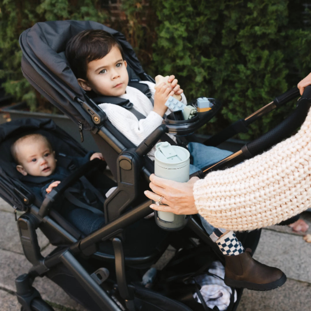 UPPAbaby Vista V3 stroller in Jake with RumbleSeat V3 carrying two children, featuring cup holder and toddler snack tray accessories