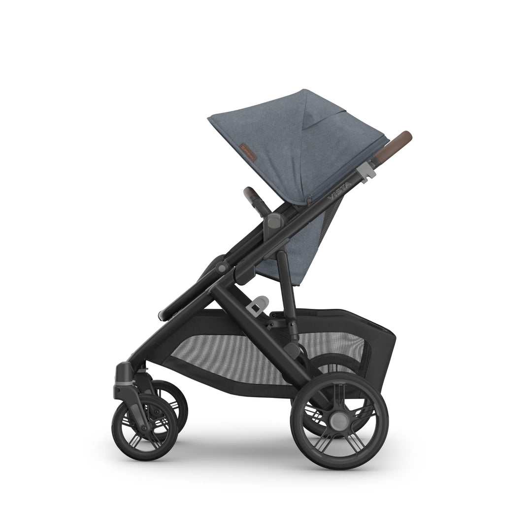 Side profile of the UPPAbaby Vista V3 stroller in Jullian blue, featuring the toddler seat with extended canopy, adjustable handlebar, large all-terrain wheels and oversized mesh storage basket on the premium Vista travel system.