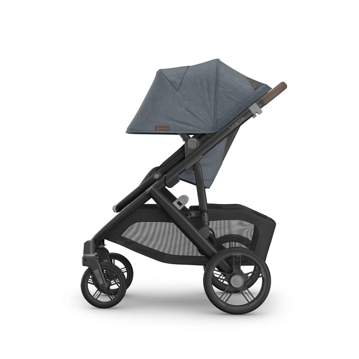 Side view of the UPPAbaby Vista V3 stroller in Jullian blue, featuring the extended toddler seat canopy, adjustable handlebar, durable all-terrain wheels and oversized mesh storage basket on the premium Vista travel system.