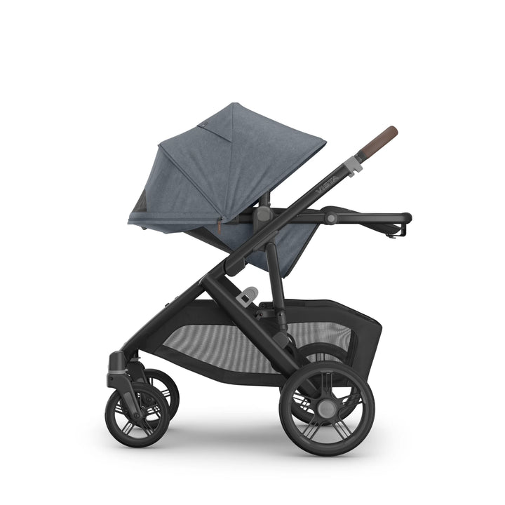 Side view of the UPPAbaby Vista V3 stroller in Jullian blue with the toddler seat in world-facing recline, featuring the fully extended canopy, adjustable handlebar, durable all-terrain wheels and oversized mesh storage basket on the premium Vista travel system.