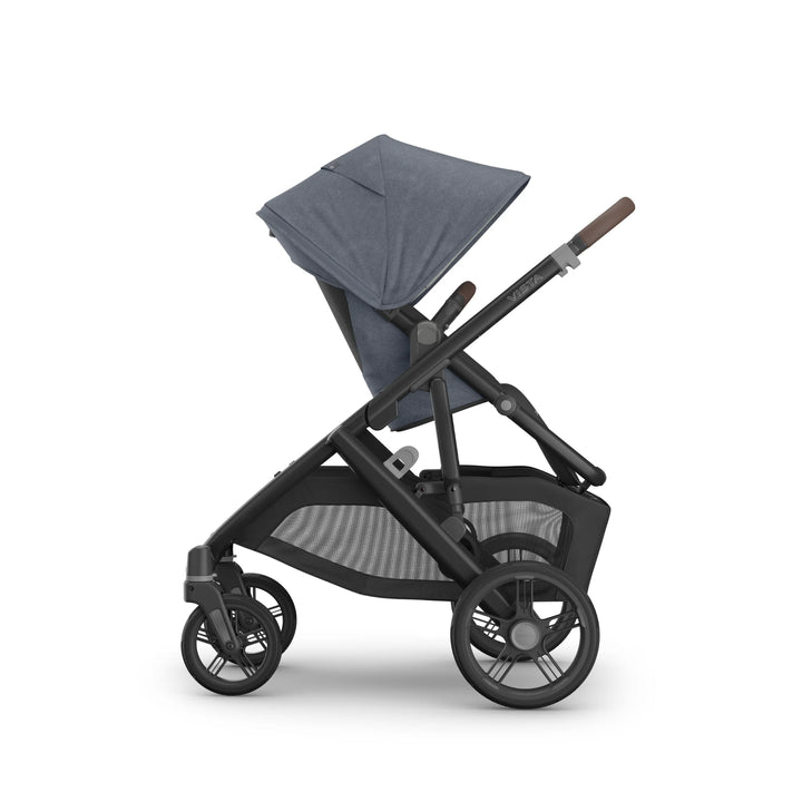 Side view of the UPPAbaby Vista V3 stroller in Jullian blue, showing the toddler seat in upright world-facing position with extended canopy, adjustable handlebar, large all-terrain wheels and spacious mesh storage basket on the premium Vista travel system.