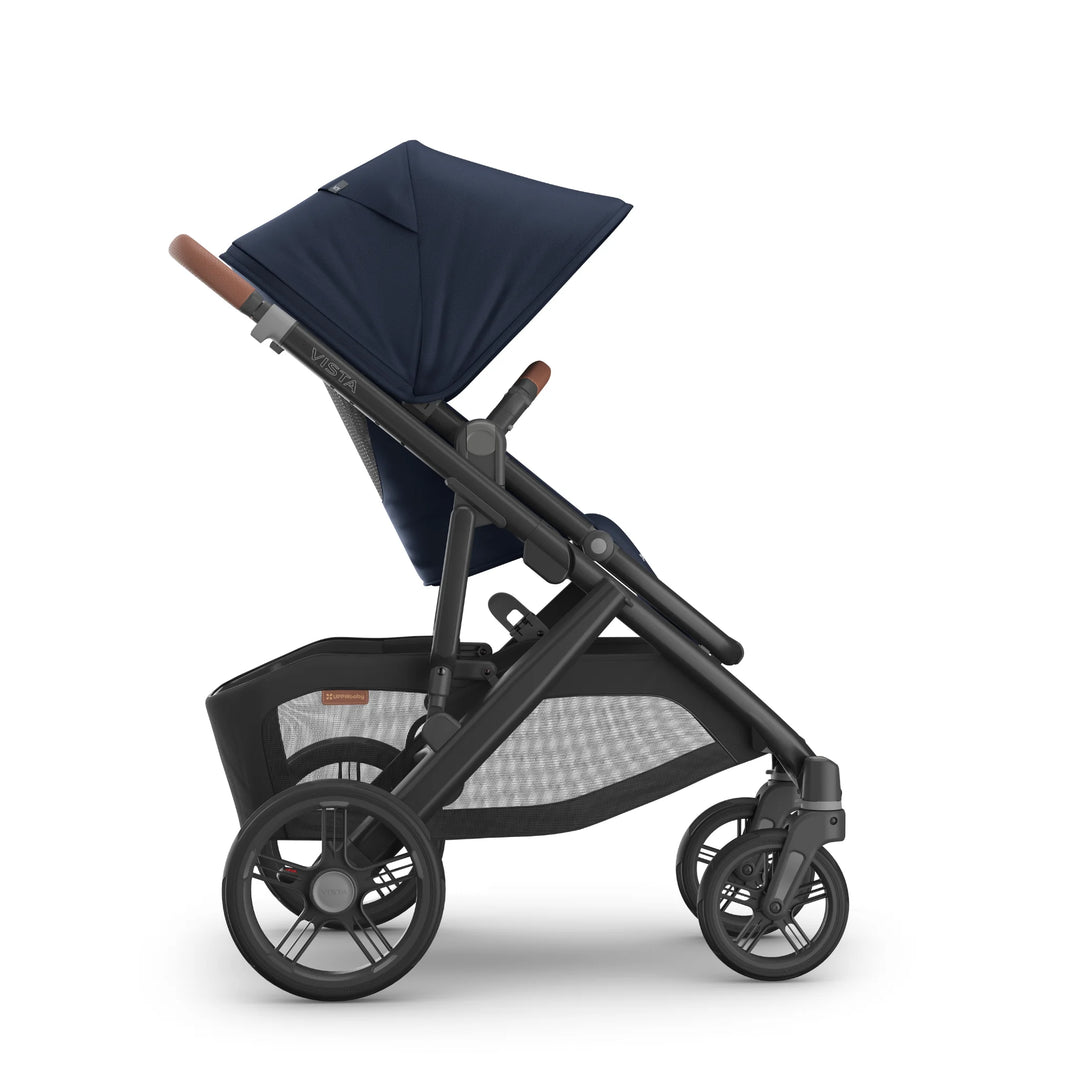 Side view of the UPPAbaby Vista V3 stroller in the Noa navy blue colourway, showing the extended canopy, ergonomic toddler seat, adjustable leather-accented handlebar, durable all-terrain wheels and spacious under-seat storage basket.