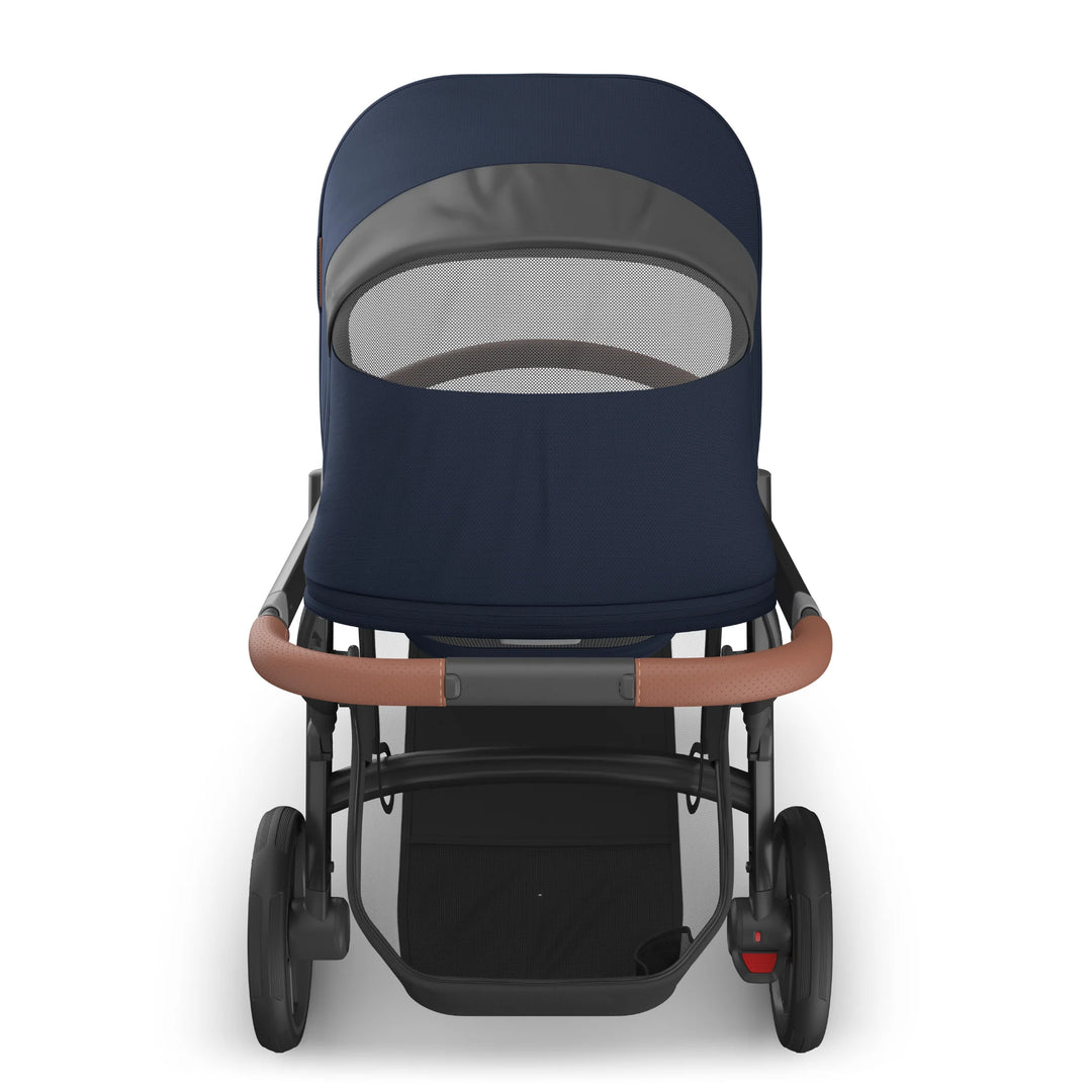 Rear view of the UPPAbaby Vista V3 stroller in the Noa navy blue colourway showing the peekaboo mesh ventilation window on the extended canopy, premium leather-accented handlebar, sturdy frame and spacious under-seat storage basket.