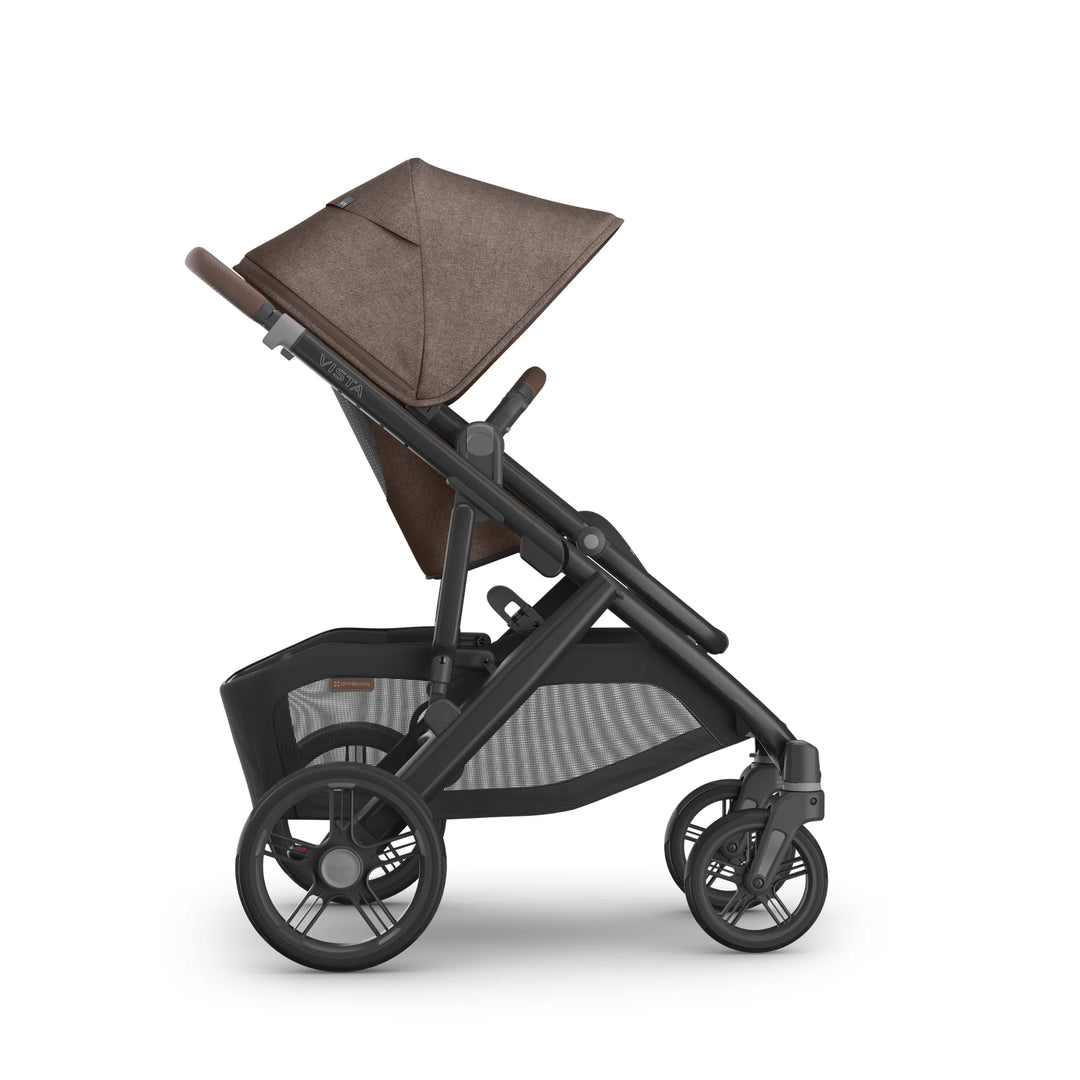 Side profile of the UPPAbaby Vista V3 stroller in Owen, showing the toddler seat in upright world-facing position with the brown textured canopy extended, adjustable leather-accented handlebar, multi-terrain wheels and extra-large mesh storage basket on the premium Vista travel system