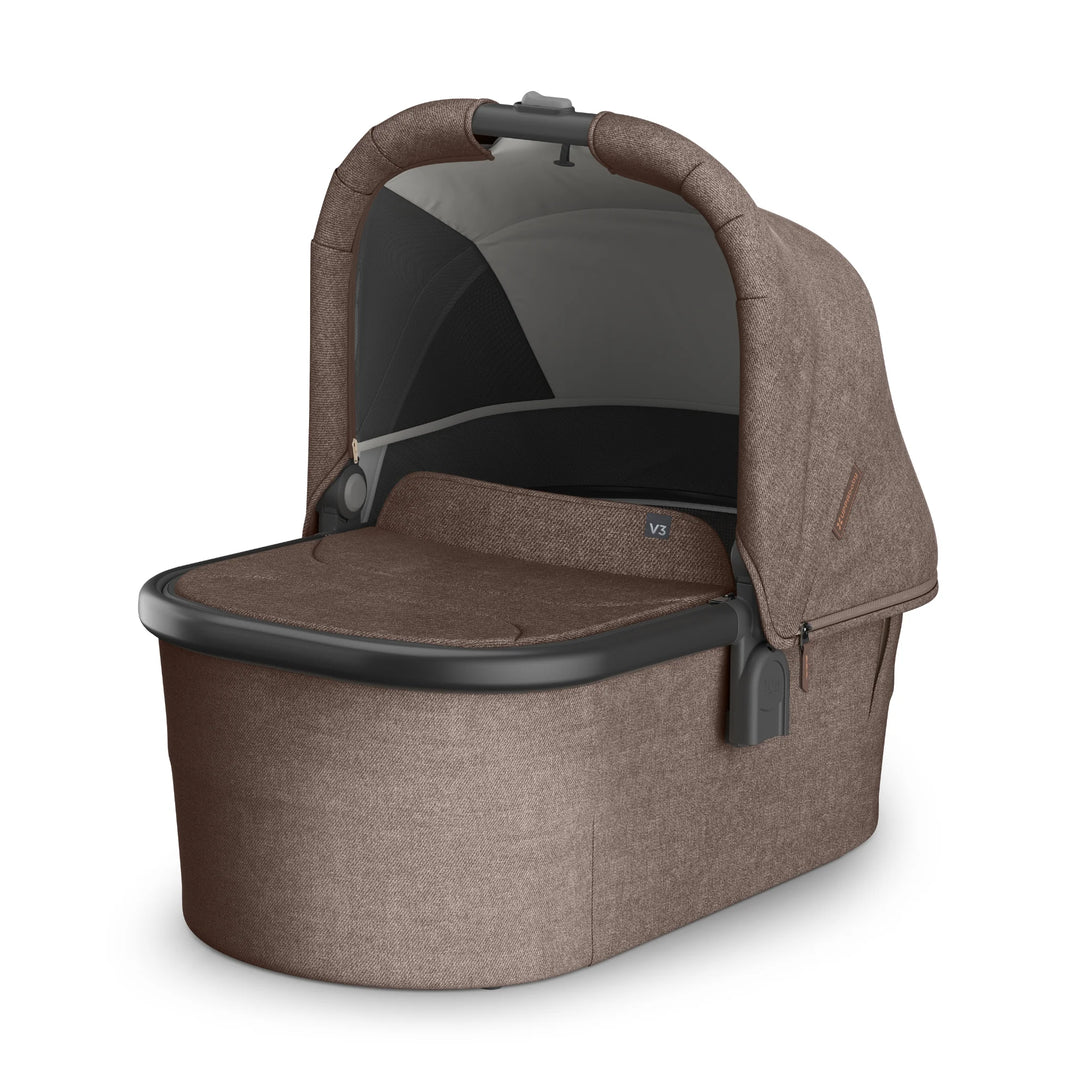 UPPAbaby Vista V3 Owen bassinet in brown fabric featuring a ventilated mesh panel, extendable canopy, padded mattress insert, and sleek black trim, displayed on a white background