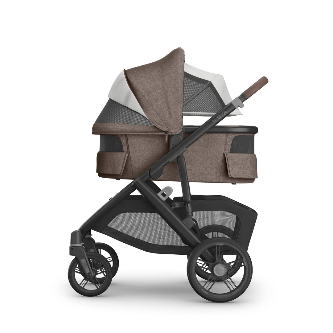 UPPAbaby Vista V3 stroller in Owen fabric shown in side view with the matching bassinet attached, featuring an extended dual-panel canopy with mesh ventilation, leather-accented handlebar, large all-terrain wheels and spacious under-seat storage basket.