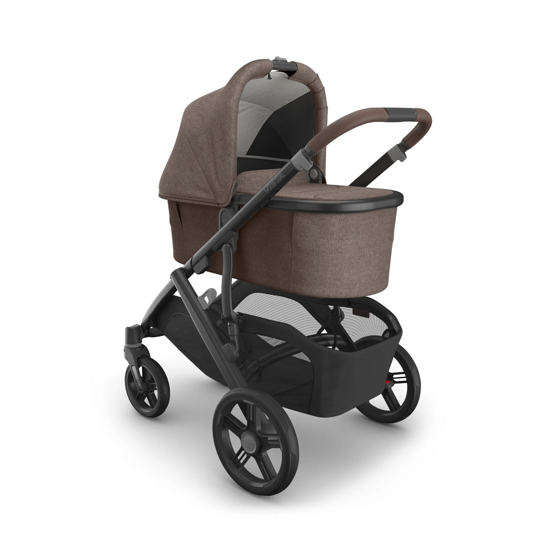 UPPAbaby Vista V3 stroller in Owen with matching bassinet attached, shown in a three-quarter view featuring the brown textured canopy, leather-accented handlebar, ventilated bassinet canopy panel, large puncture-resistant wheels and spacious under-seat storage basket.