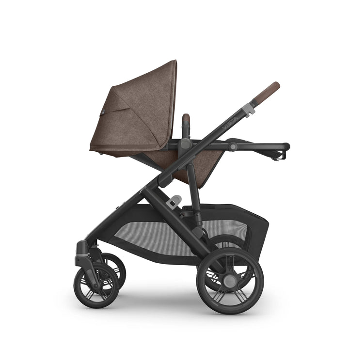 Side view of the UPPAbaby Vista V3 stroller in Owen, featuring the toddler seat in a fully reclined world-facing position with the brown textured canopy extended, adjustable leather-accented handlebar, multi-terrain wheels and spacious mesh storage basket on the premium Vista travel system.