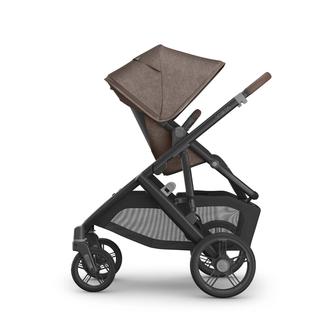 Side view of the UPPAbaby Vista V3 stroller in Owen, showcasing the toddler seat in upright world-facing position with the brown textured canopy extended, adjustable handlebar, durable all-terrain wheels and spacious mesh storage basket on the premium Vista travel system.