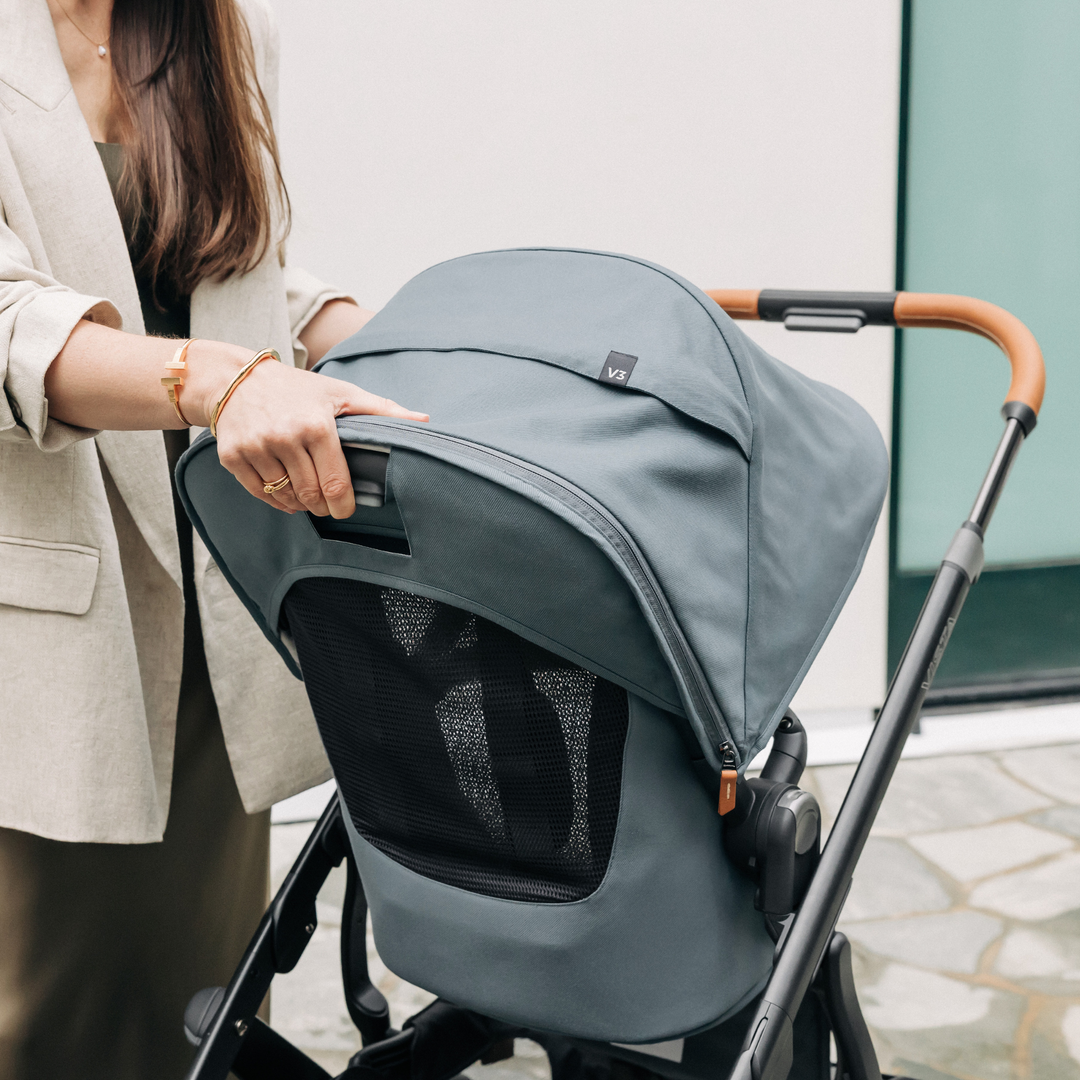 This image shows the Vista V3 in Dillan with a Mum pushing the button to recline the toddler seat.