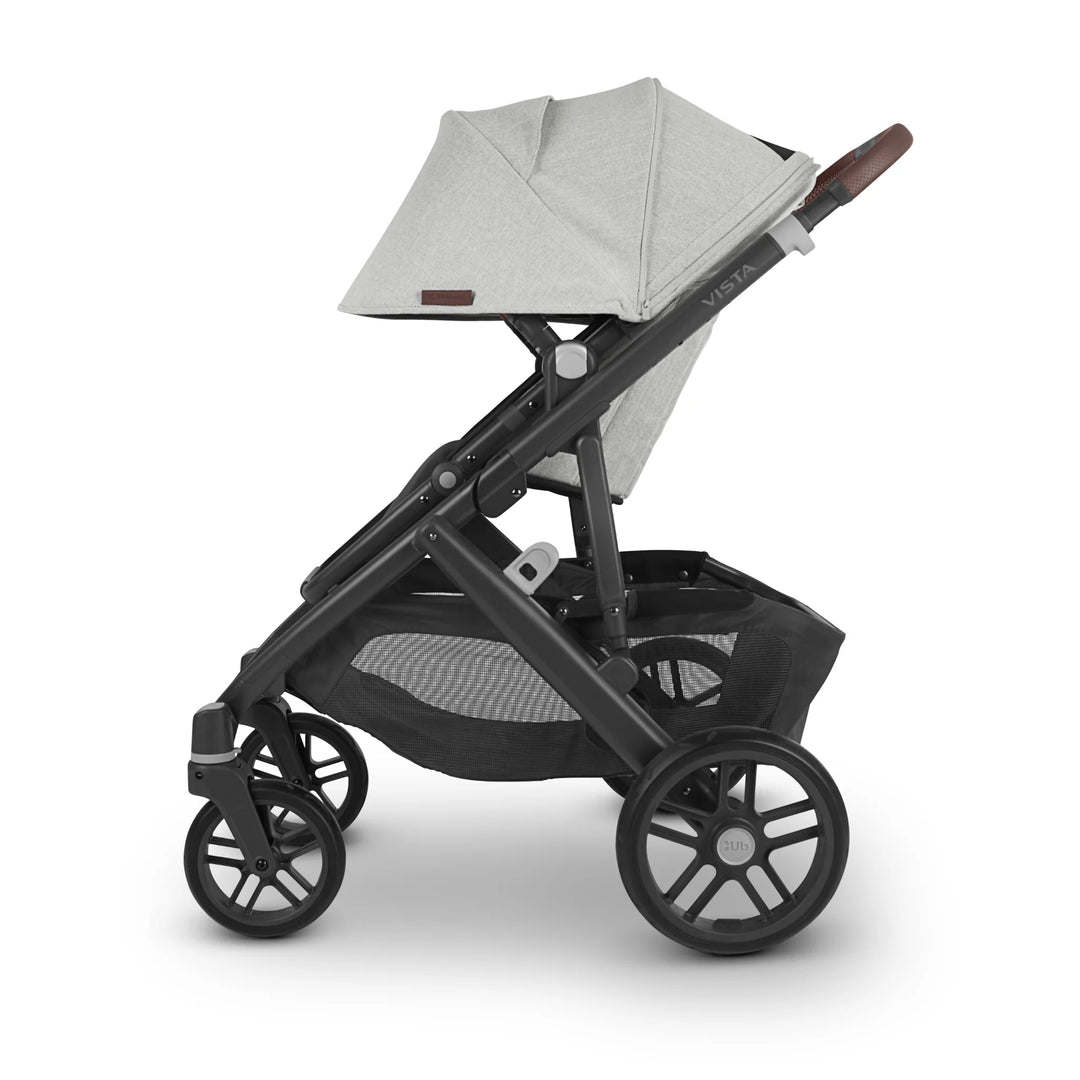 “Side view of UPPAbaby Vista V2 Anthony pushchair in light grey with brown leather handle and black frame, featuring extendable canopy, large storage basket, and durable wheels — premium baby stroller designed for comfort and style.