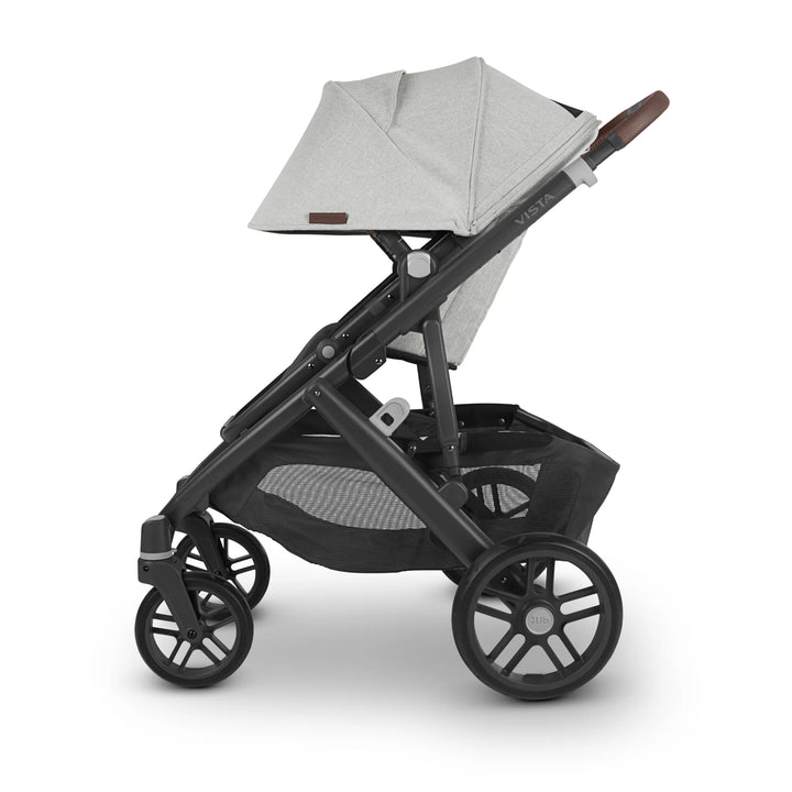 “Side view of UPPAbaby Vista V2 Anthony pushchair in light grey with brown leather handle and black frame, featuring extendable canopy, large storage basket, and durable wheels — premium baby stroller designed for comfort and style.