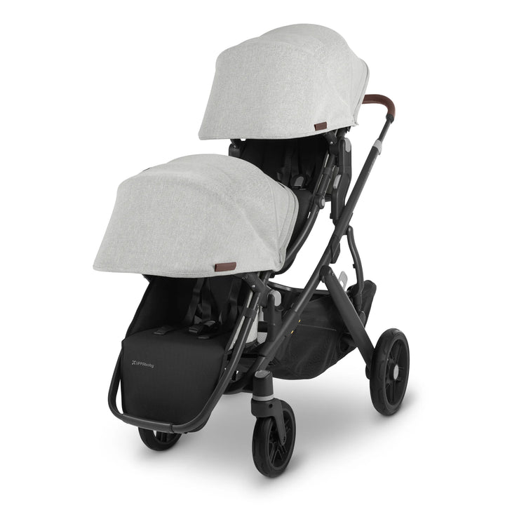 UPPAbaby Vista V2 Anthony double pushchair in light grey fabric with black frame and brown leather handle, featuring two toddler seats with extendable canopies and large underseat basket — versatile tandem stroller for growing families.