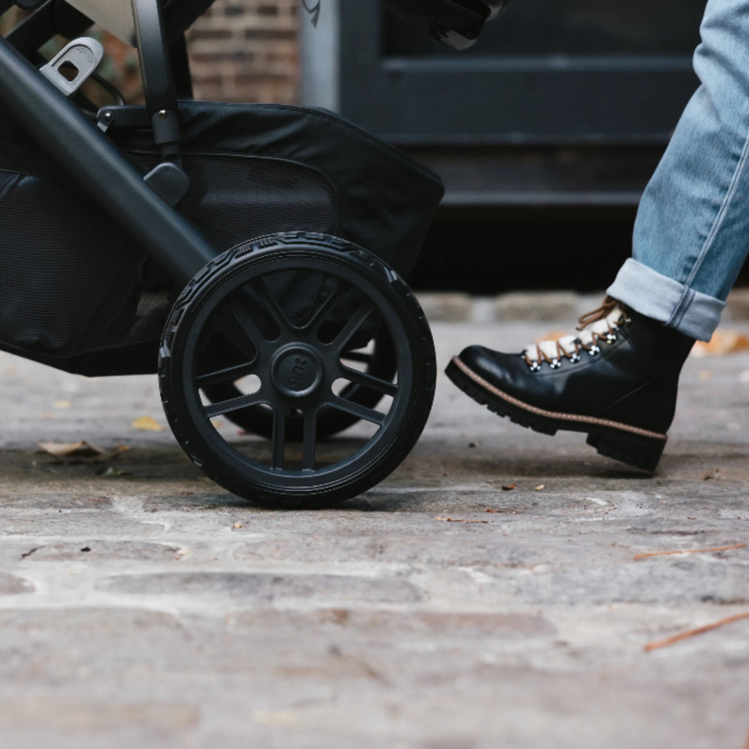 “UPPAbaby Vista V2 all-terrain stroller wheel in use on city pavement, durable replacement wheel set”