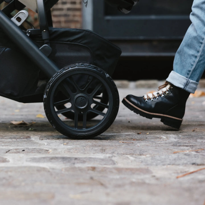 “UPPAbaby Vista V2 all-terrain stroller wheel in use on city pavement, durable replacement wheel set”