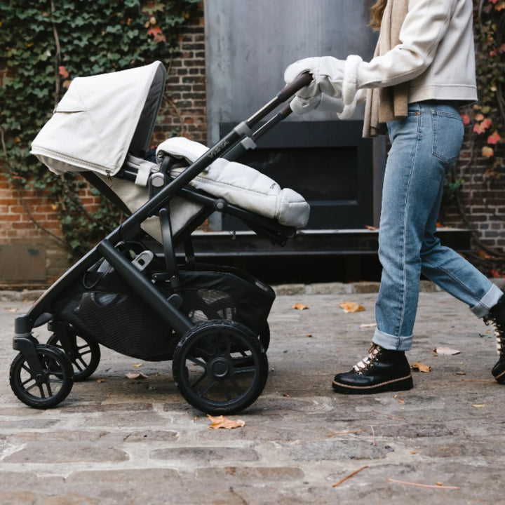 “UPPAbaby Vista V2 stroller with all-terrain wheels in use, parent pushing stroller on outdoor path”