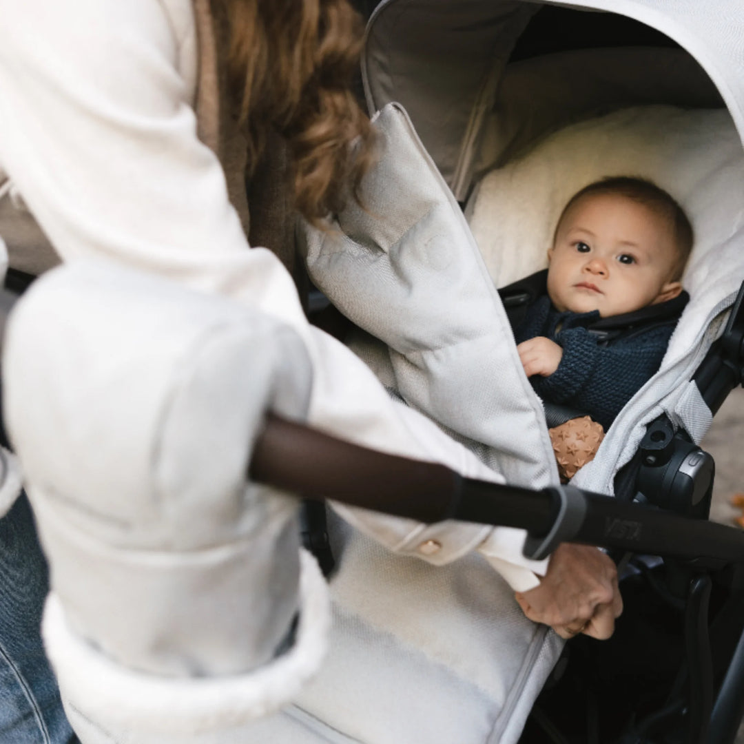 UPPAbaby Cozy Ganoosh footmuff and Cozy Handmuffs in Savannah grey on a UPPAbaby stroller, keeping baby and parent warm with fleece-lined winter stroller accessories.