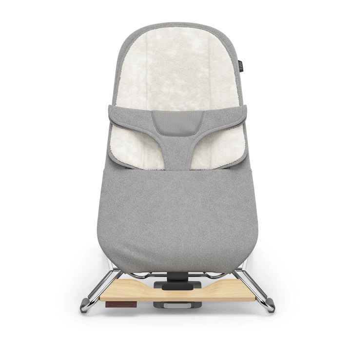 UPPAbaby Mira Bouncer in Stella grey shown front-facing on a white background, featuring plush newborn insert, breathable mesh support panel, ergonomic infant harness, and modern lightweight frame with natural wood base accent.