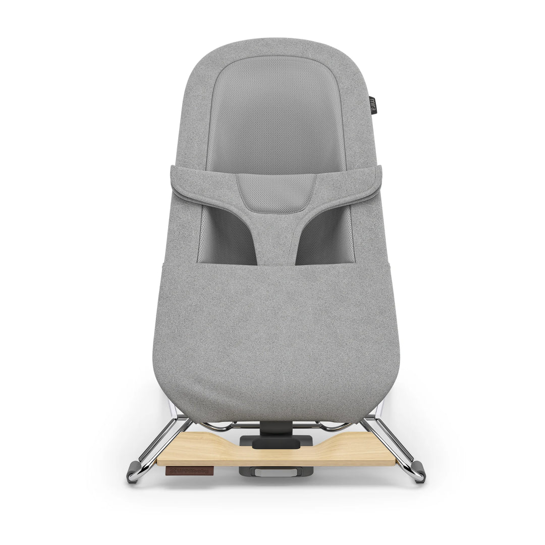 “UPPAbaby Mira Bouncer in Stella grey shown front-facing on a white background, featuring breathable mesh seat panel, ergonomic infant harness, soft textured upholstery, and modern lightweight frame with natural wood base accent.”