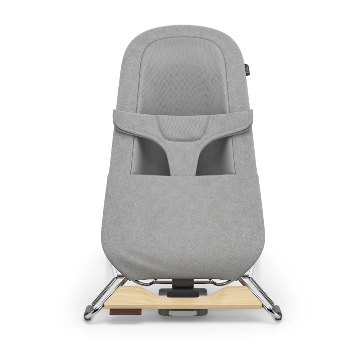 “UPPAbaby Mira Bouncer in Stella grey shown front-facing on a white background, featuring breathable mesh seat panel, ergonomic infant harness, soft textured upholstery, and modern lightweight frame with natural wood base accent.”