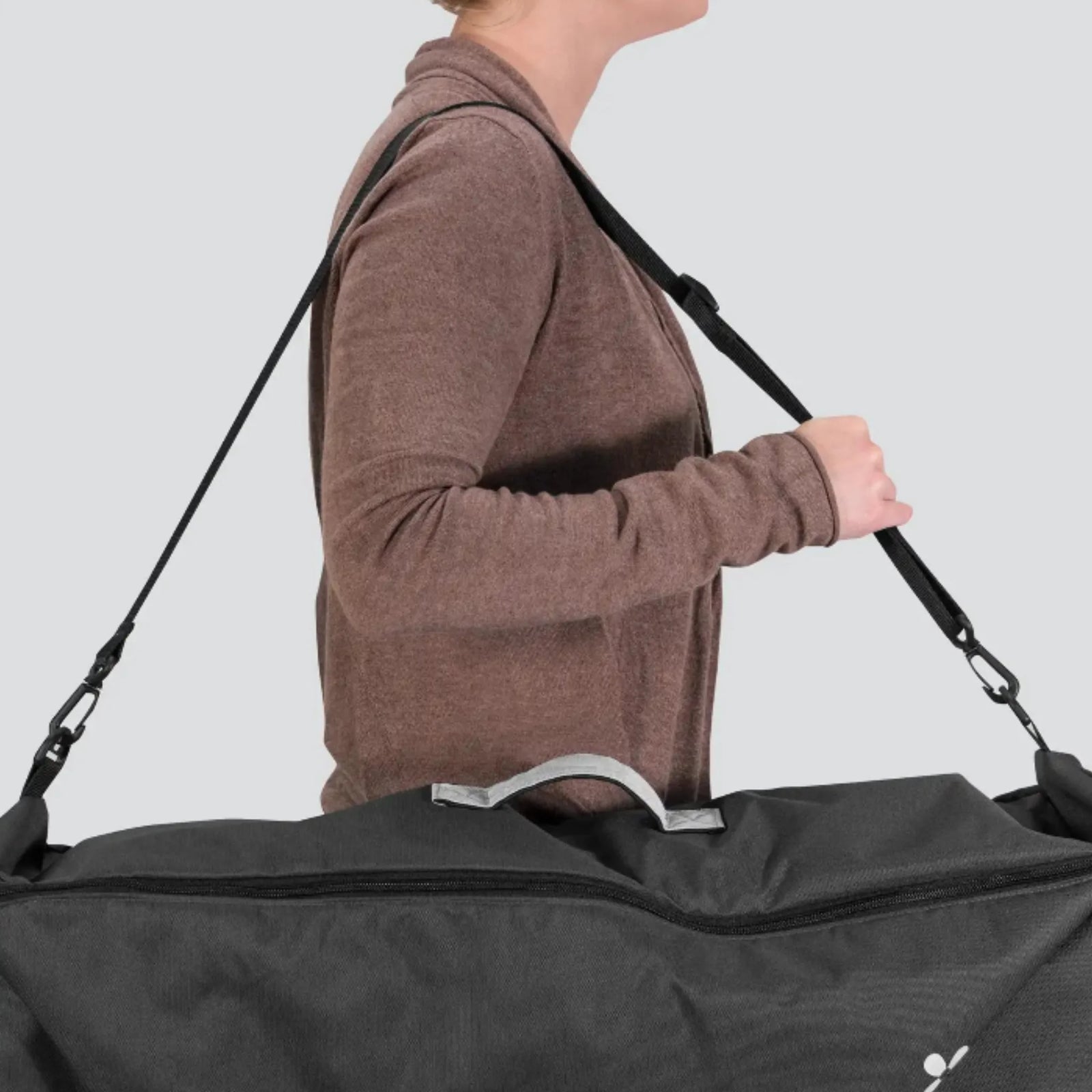 erson carrying the UPPAbaby travel bag for Carry Cot and RumbleSeat using the shoulder strap