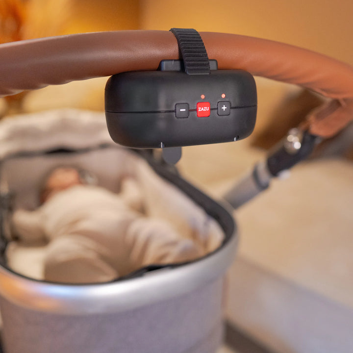 ZAZU Robby the Rocker automatic baby rocker attached to a stroller handle, gently rocking a sleeping baby in a pram — smart portable device for soothing infants and promoting better sleep on the go.