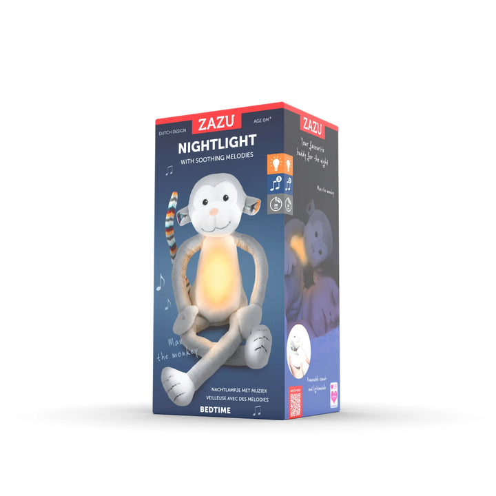 Zazu Max soft toy nightlight retail packaging featuring the plush grey monkey with glowing belly, soothing melodies, bedtime light functions, and product details displayed on a blue box.